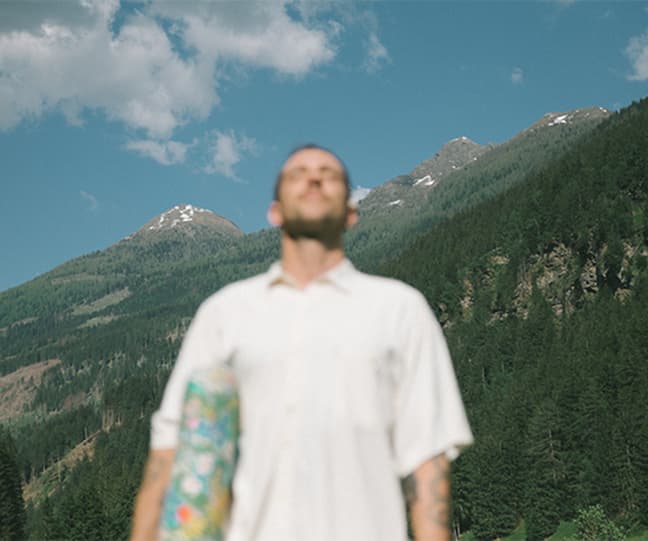 Person in white shirt with mountains in the background